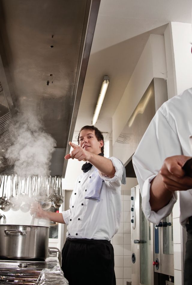 Professional Chef teaching young culinary student the art of cooking.  All images shot in a hotel's commercial kitchen.