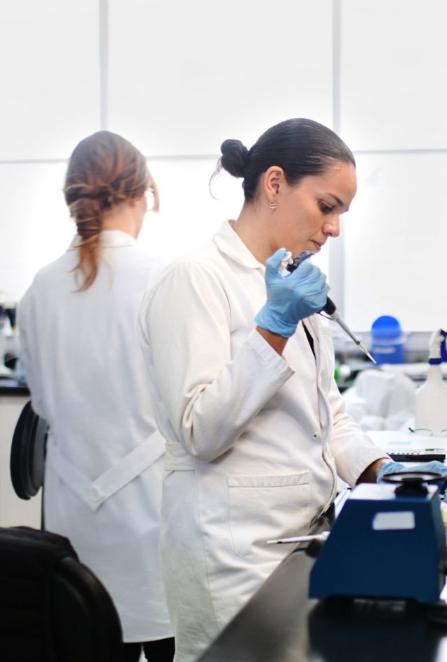 Researchers work in a scientific lab filling tubes with a substance