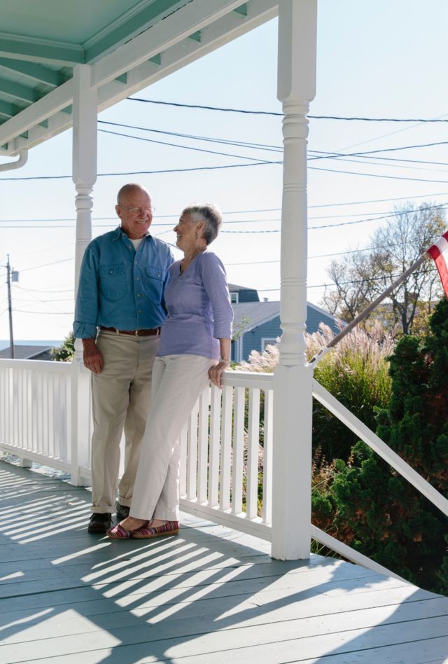 Stock Photo of Senior Couple Relaxing on Front Porch of Home 