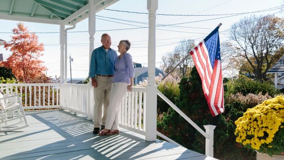 Stock Photo of Senior Couple Relaxing on Front Porch of Home 