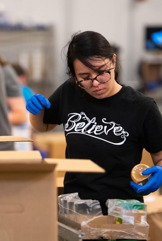 2BDTF9G Washington, United States. 09th Apr, 2020. A volunteer packs a box of food to be distributed to people in need at the Capital Area Food Bank on Thursday, April 9, 2020 in Washington, DC. The Capital Area Food Bank provides over 30 million meals per year with its non-profit partners in D.C., Maryland and Virginia. Since the COVID-19 pandemic food banks around the country have seen an uptick in demand as unemployment has surged around the country. Photo by Kevin Dietsch/UPI Credit: UPI/Alamy Live News