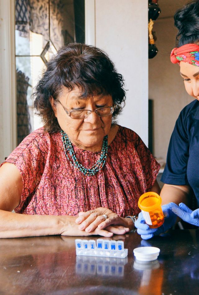 An Indigenous Navajo senior aged woman, receiving healthcare assistance in her home.