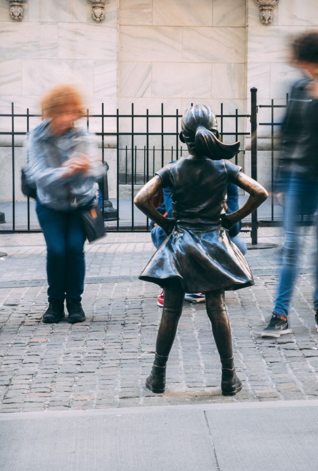 People walk by and stop to take pictures of New York City's "Fearless Girl" statue