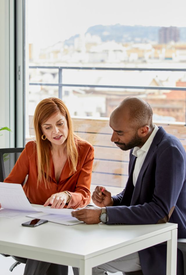 Female financial advisor with a customer signing a contract in his office