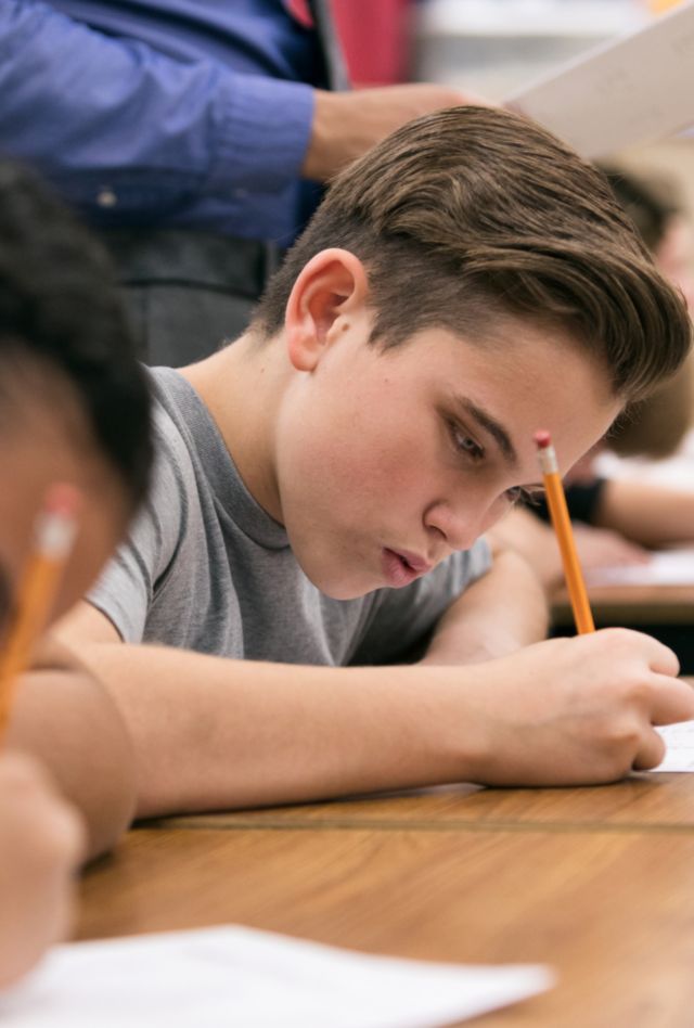 Students write on papers in a classroom
