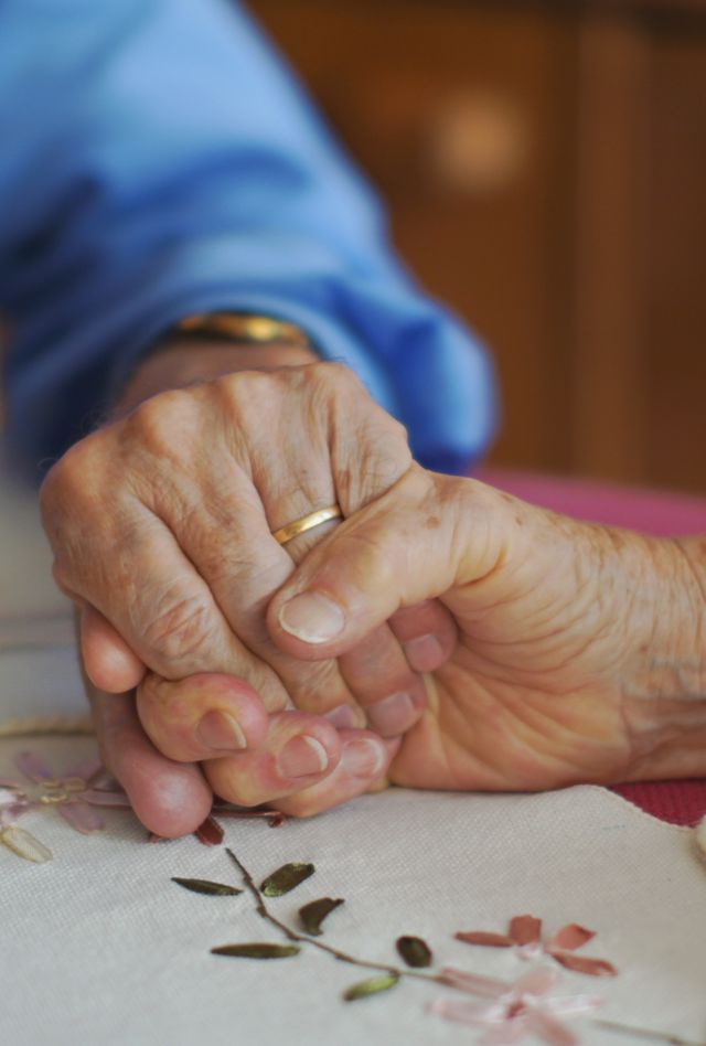 85 year old mature senior couple at home holding hands, in love, married 60 years. This senior love couple  are  aging together, holding hands. Senior healthcare at home