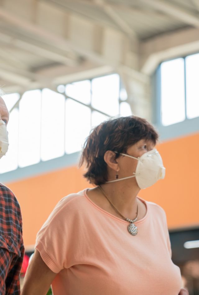 Stock Photo Of Senior Couple With Respirators Walking At Shopping Mall Together