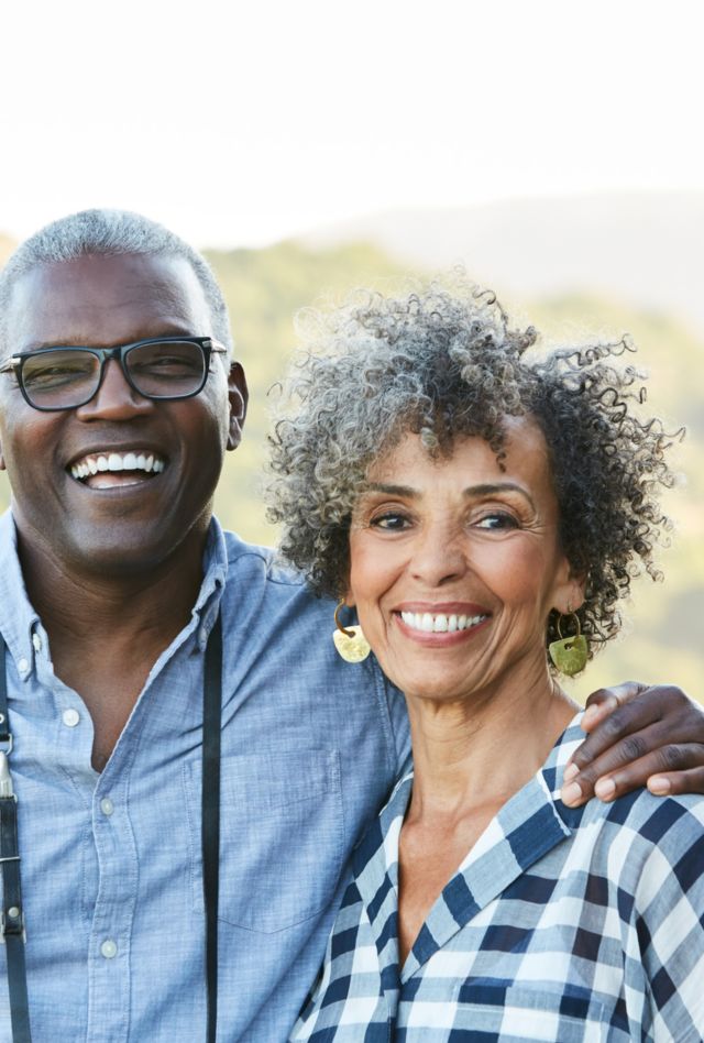 Portrait of senior African American senior couple in nature with camera