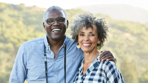 Portrait of senior African American senior couple in nature with camera