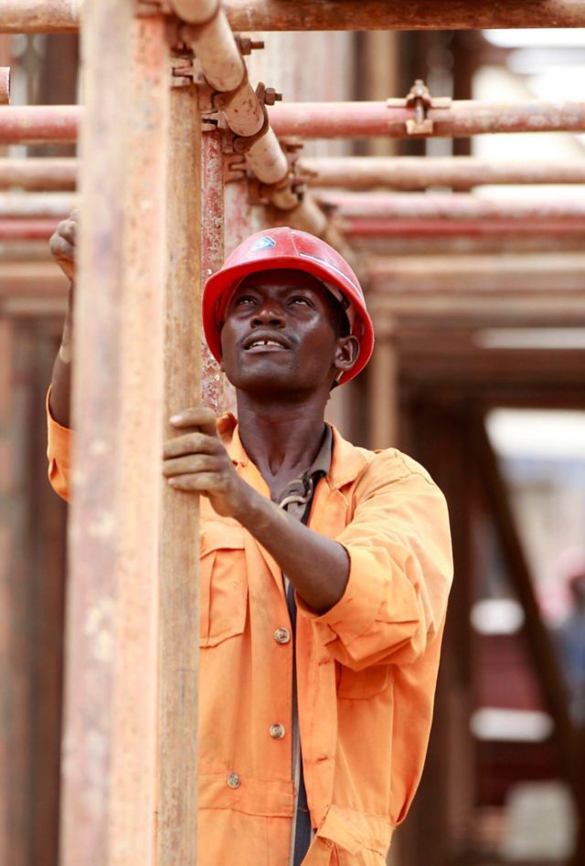 A construction worker erects a scaffolding on a tunnel