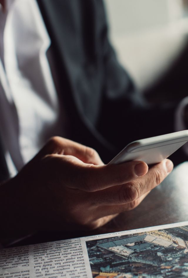 Hands of unrecognisabe businessman typing on his cell phone.