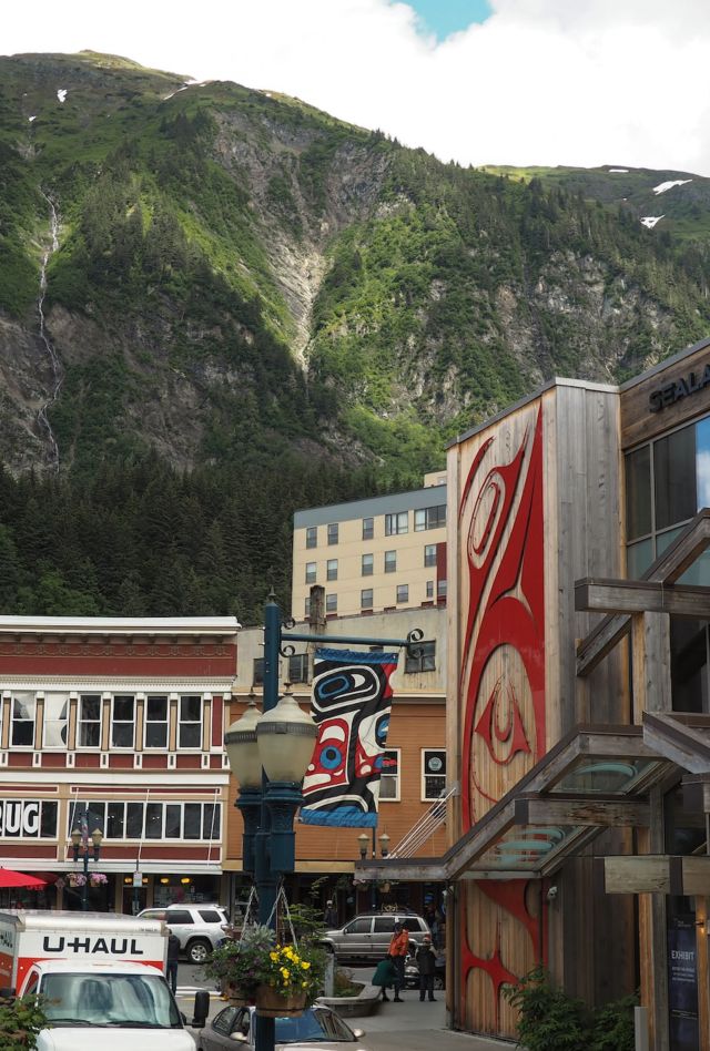 A busy street surrounded by buildings with a mountain in the background