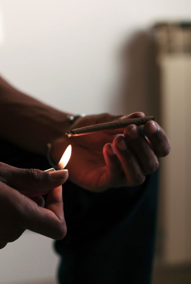 Male hands lighting a cannabis (marijuana) joint.