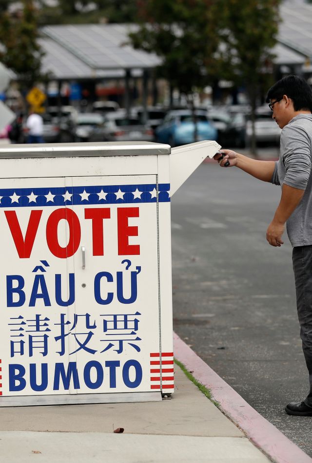 People with signs at a Stop Asian Hate rally.