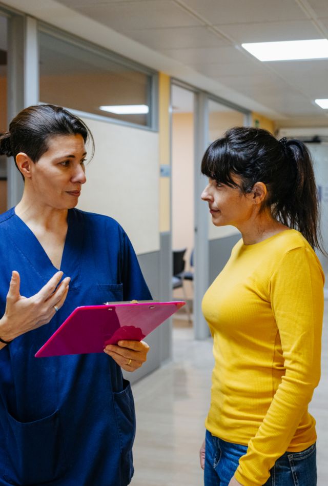 Female doctor attending a patient in the hospital corridor