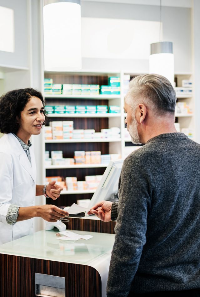 A customer being served his prescription at his local pharmacy in the city.