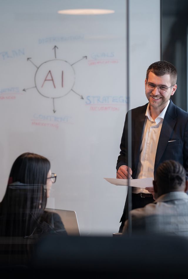 Diverse business team in a modern office during a meeting, discussing artificial intelligence strategy. Concept of AI innovation, teamwork, leadership, corporate planning, professional collaboration.