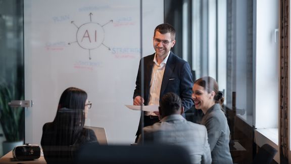 Diverse business team in a modern office during a meeting, discussing artificial intelligence strategy. Concept of AI innovation, teamwork, leadership, corporate planning, professional collaboration.