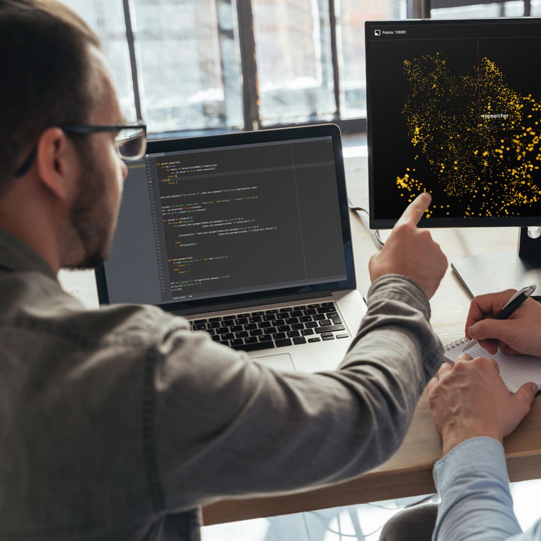 Closeup of two men data science specialists working at office together, analyzing big data on screen. Coders working on new project