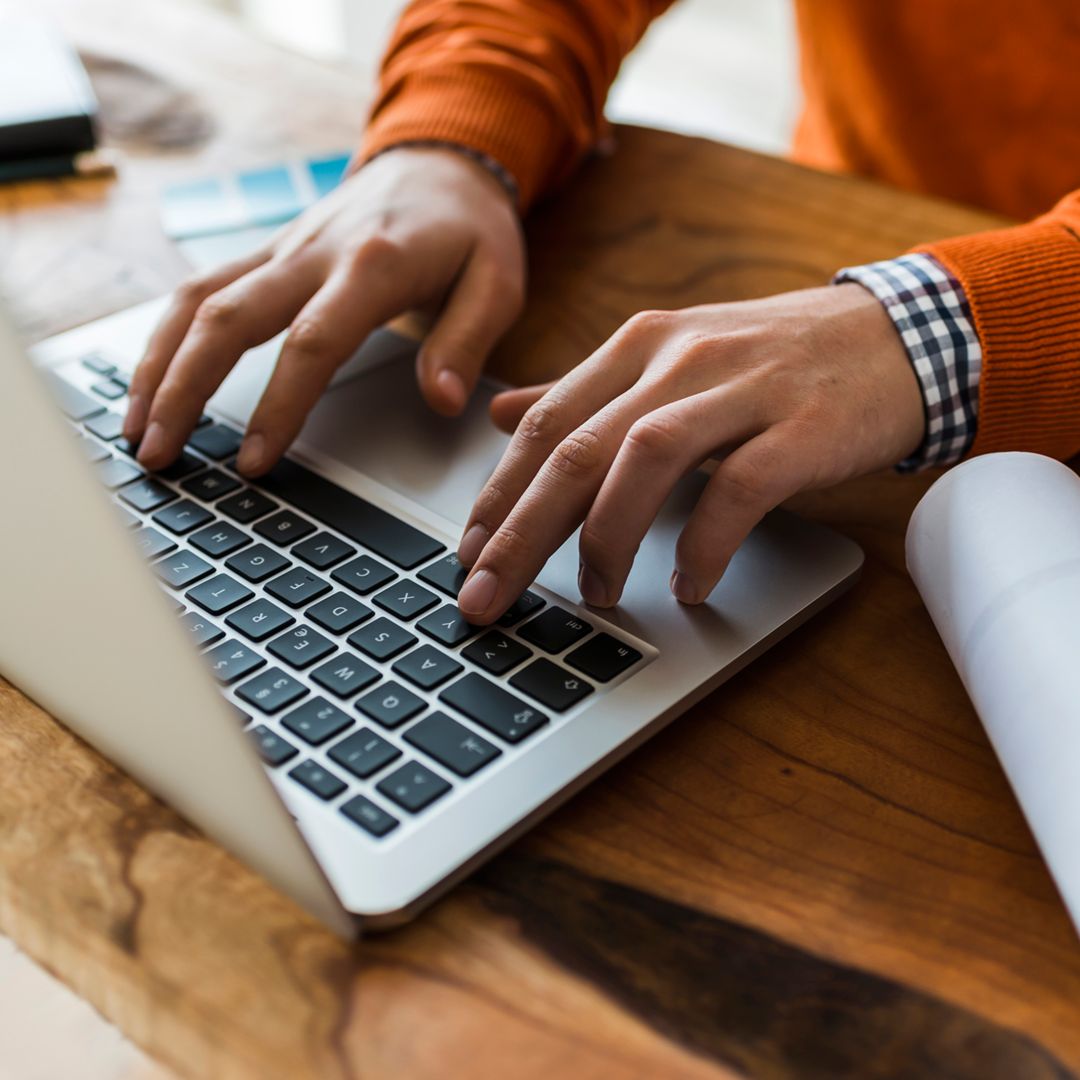 closeup image of hands typing on a laptop