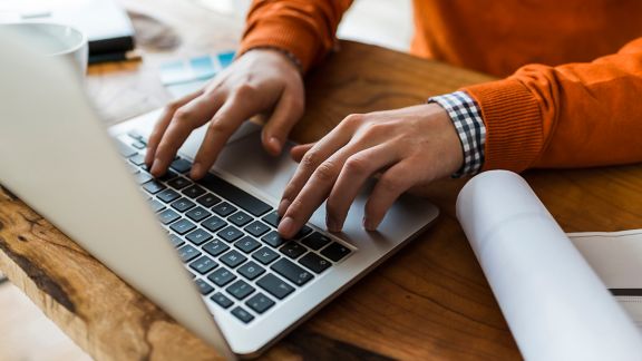 closeup image of hands typing on a laptop