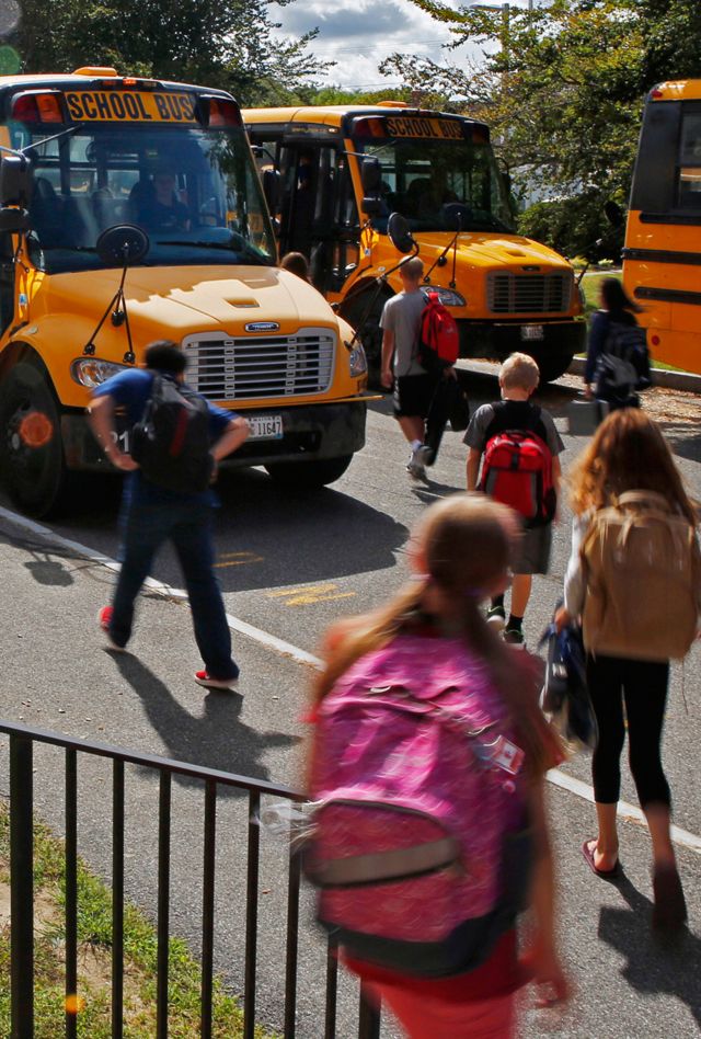 In this Thursday, Sept. 14, 2017 photo students head for their buses at York Middle School in York, Maine. A shortage of school bus drivers in some communities in New England and across the country is causing headaches for school districts this fall. (AP Photo/Robert F. Bukaty)