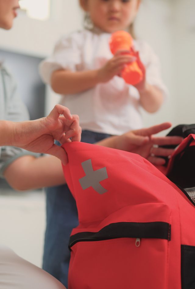 A woman checking the items and preparing an emergency bag in the living room at home.
