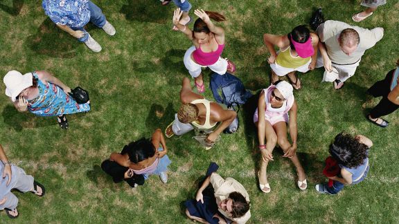 aerial image of people sitting and standing on a park lawn