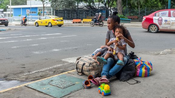 Refugee family asking for money on urban street 