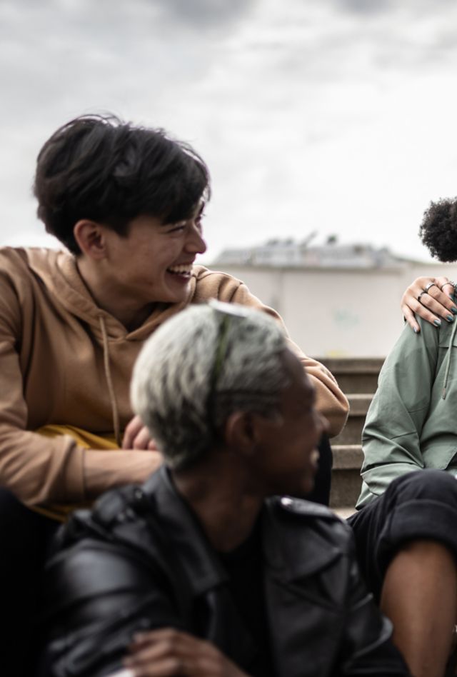 Diverse group of young people laughing together outside