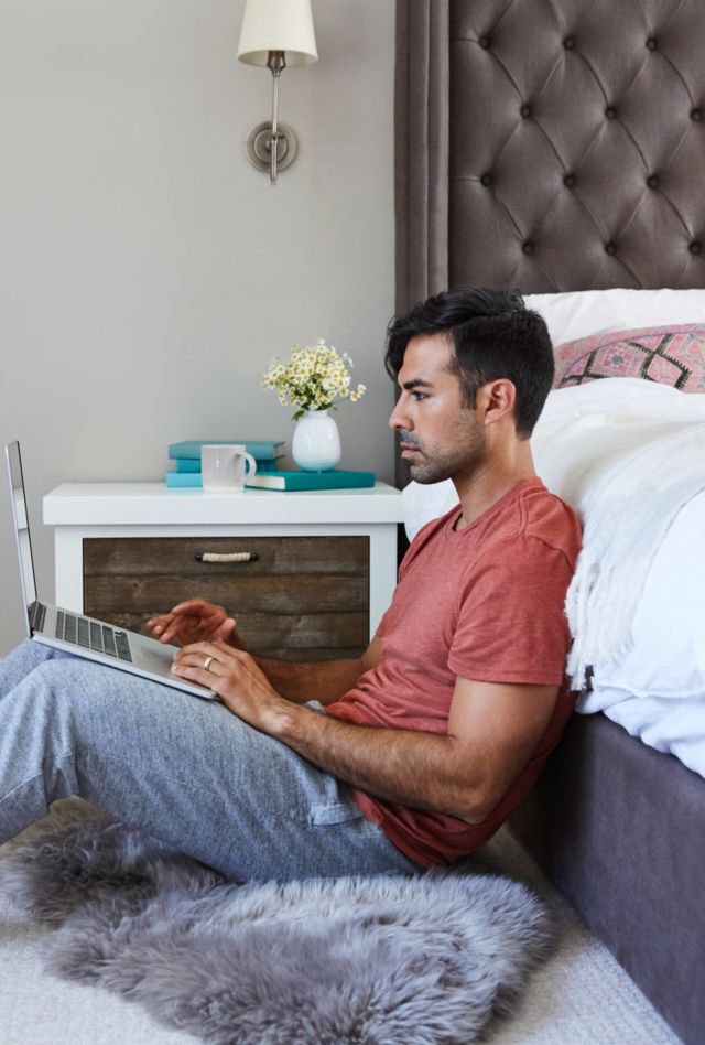 Young millennial hispanic man working remotely on a laptop at home in his bedroom