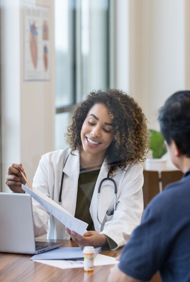 The mature adult couple pays careful attention as the mid adult female doctor points out the test results.