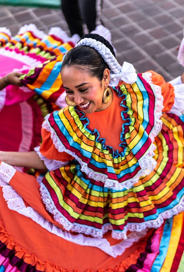 adult woman dancing in colorful dress at public park