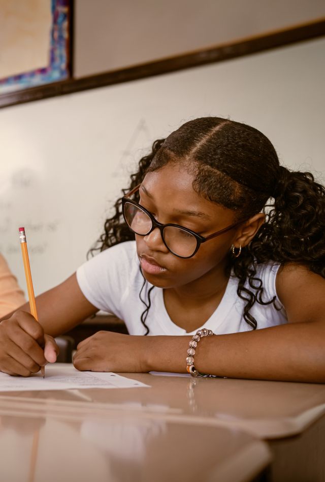 Junior-high Black students attend a math class at school.  They participate in math lesson and solve math problems.