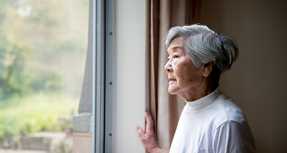 Chinese senior woman looking outside.