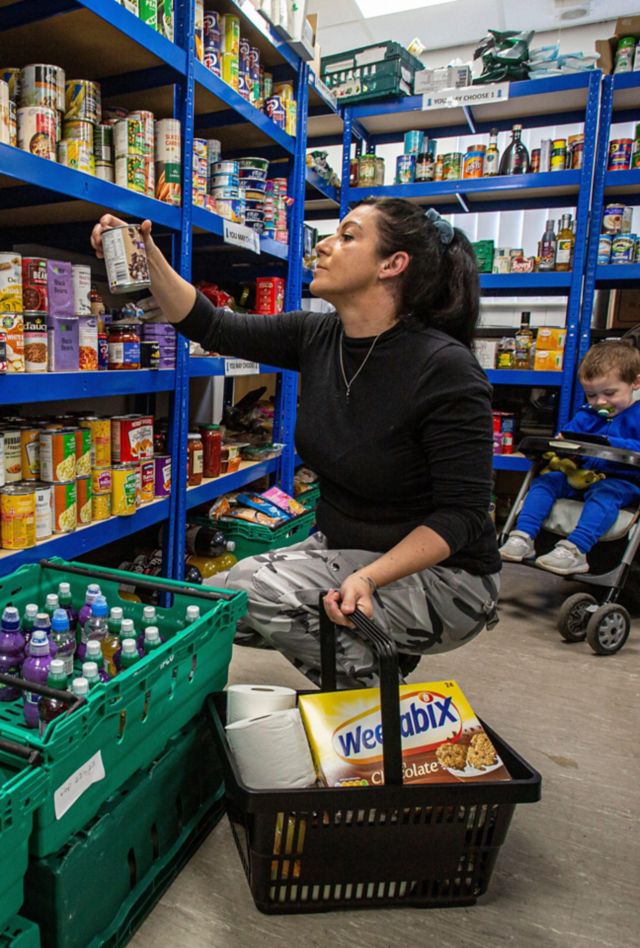 Woman with child at shelf stocked with food