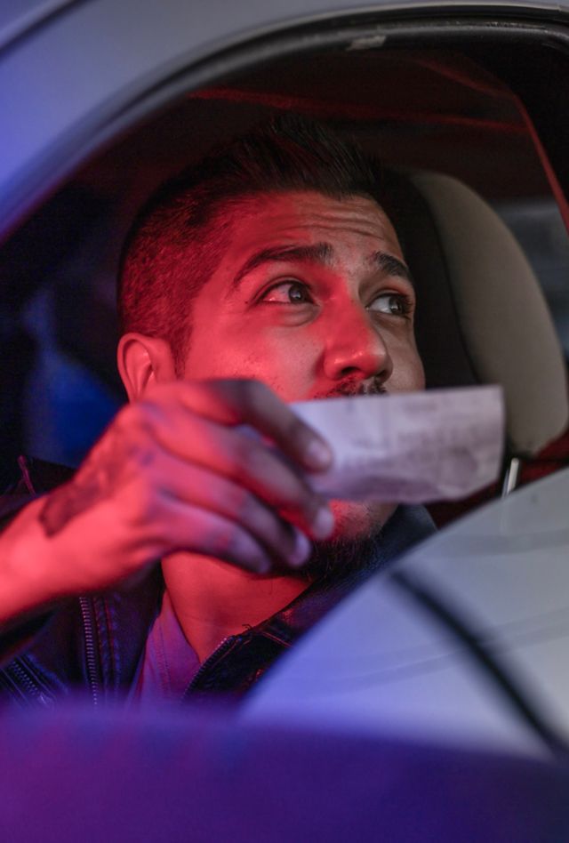 A man being pulled over by the police at night