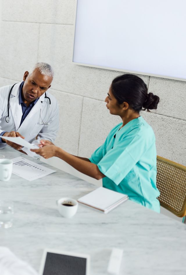 Diverse group of health professionals meet around a conference table