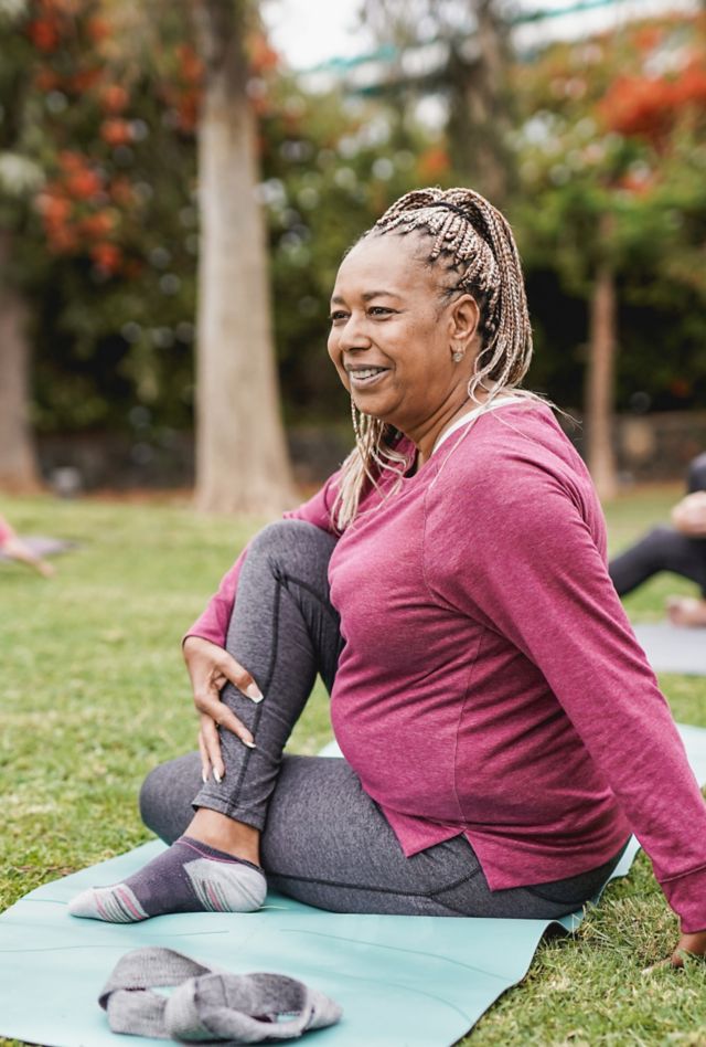 Multiracial women doing yoga exercise with social distance for coronavirus outbreak at park outdoor - Healthy lifestyle and sport concept