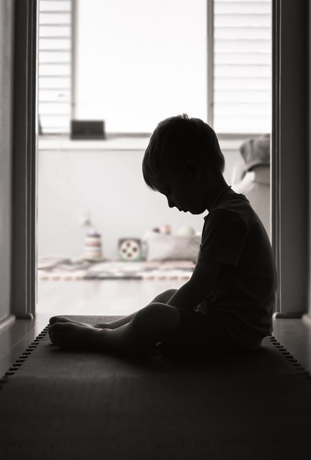 child sitting in hallway alone