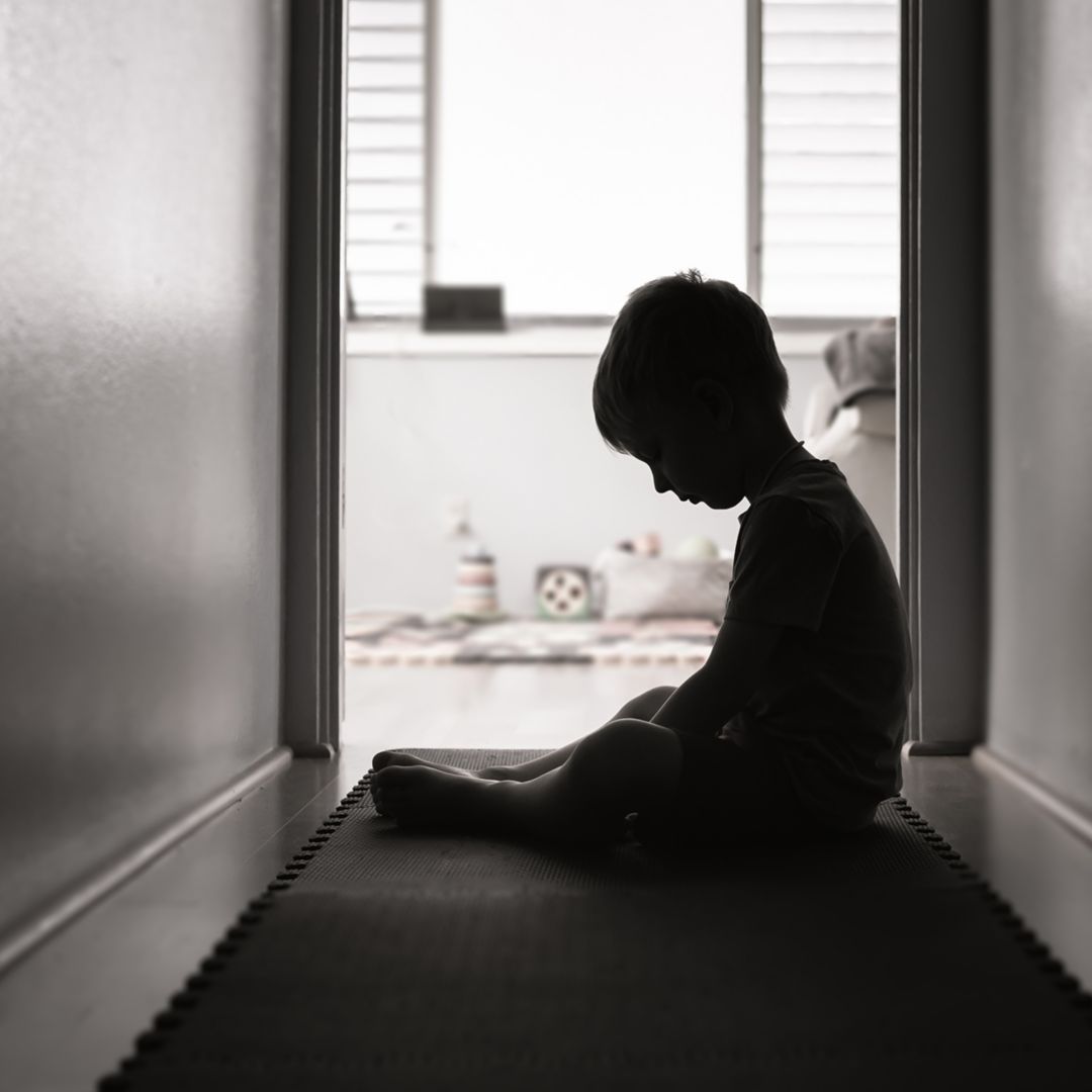child sitting alone in a hallway
