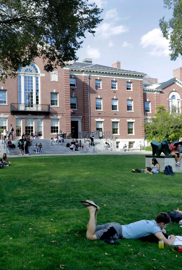 FILE - In this Sept. 25, 2019, file photo, people rest on grass while reading at Brown University in Providence, R.I. The university and attorneys for student-athletes, who challenged the Ivy League school's decision to reduce several women's varsity sports teams to club status, announced a proposed settlement Thursday, Sept. 17, 2020. (AP Photo/Steven Senne, File)