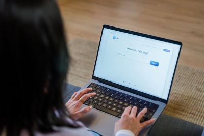 Person using laptop computer interacting with an artificial intelligence chatbot