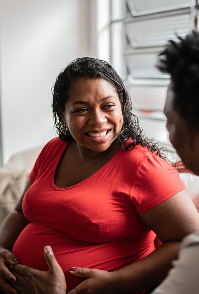 Husband touching pregnant wife's abdomen at home