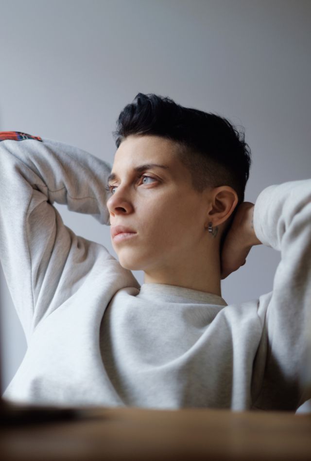 Young tomboy female relaxing while working online with her laptop indoor daylight portrait shot