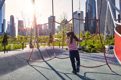 Little girl playing at playground with Chicago's financial district in the background.