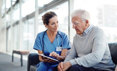 Cropped shot of a female nurse showing her patient something on a digital tablet