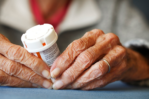 Close up of Senior citizen female holding a bottle of prescription medicine.
