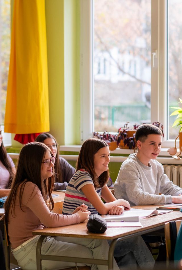 Group of teenage kids sitting in the classroom during tha class and listening teacher