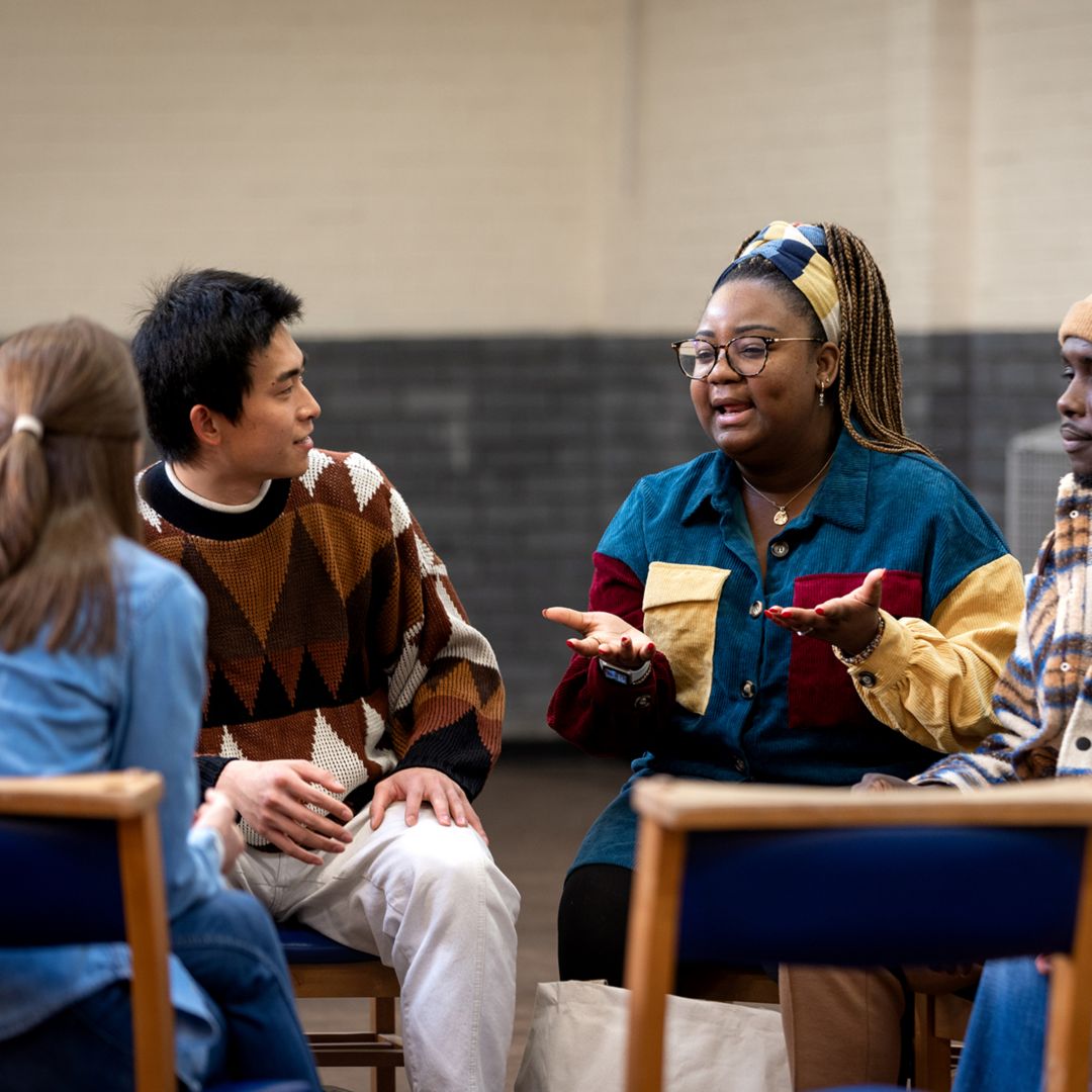 A group of adults of speaking in a circle